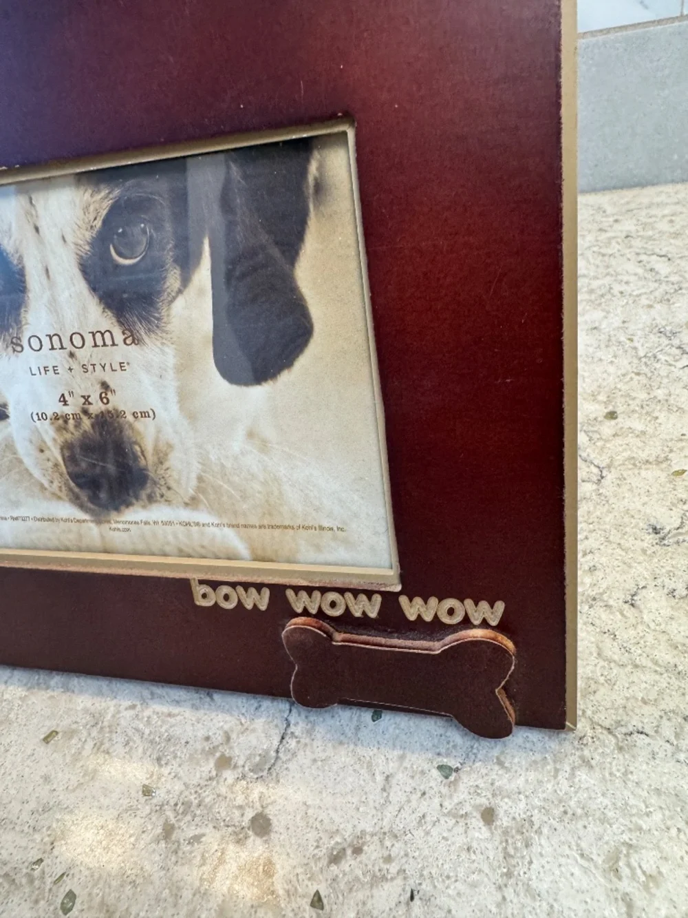 A Sonoma Life & Style brown wood picture frame with dog bone and bow wow wow